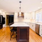 Kitchen remodel with white cabinets, custom wood range hood and hexagon tile backsplash