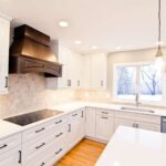 Kitchen remodel with white cabinets, custom wood range hood and hexagon tile backsplash