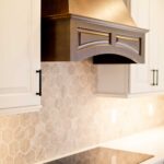 Kitchen remodel with white cabinets, custom wood range hood and hexagon tile backsplash