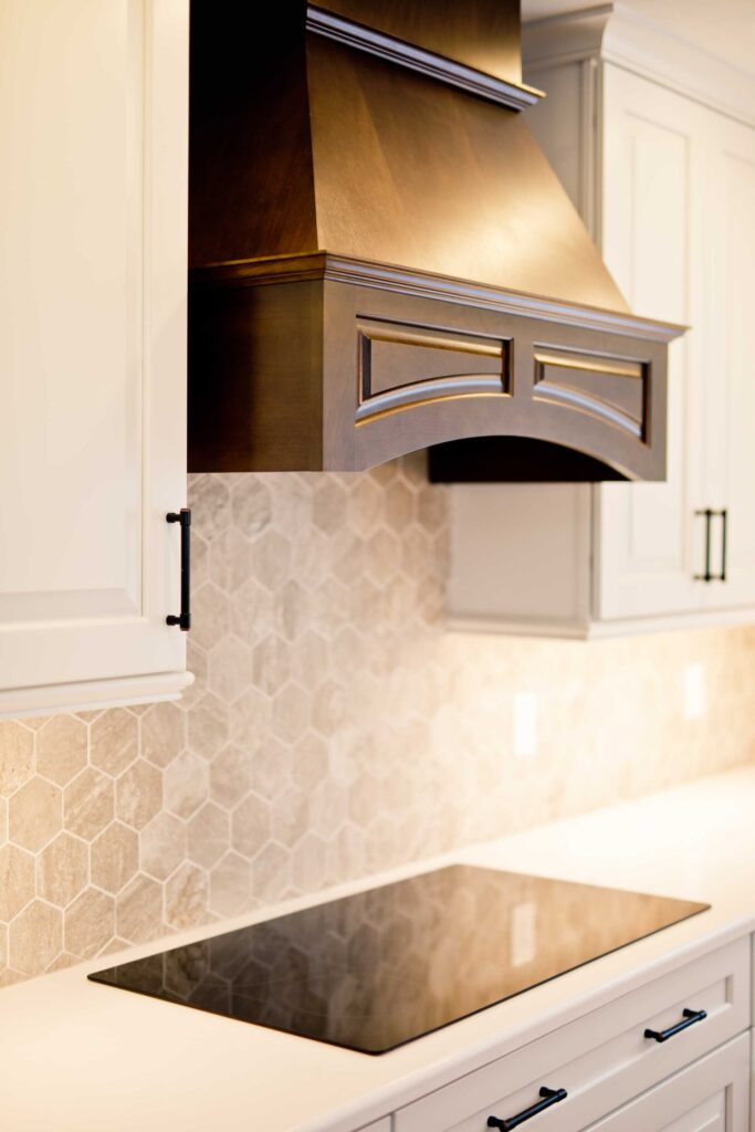 Kitchen remodel with white cabinets, custom wood range hood and hexagon tile backsplash